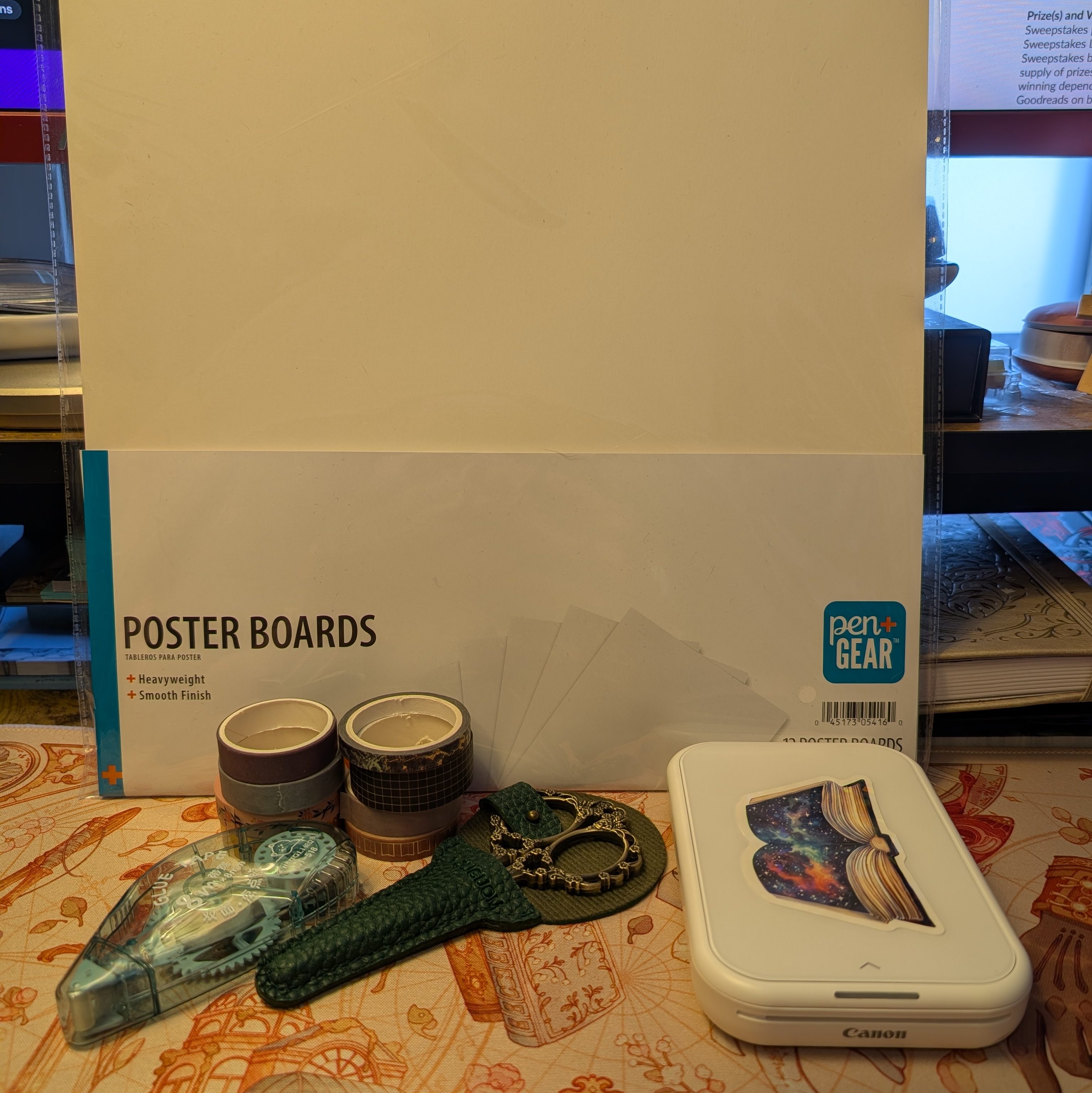 A picture of the materials used for this tutorial including poster board, washi tape, scissors, a Canon Ivy printer, and glue tape